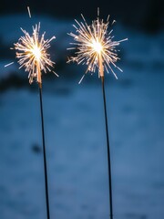 Obraz premium Two burning sparklers in the snow, creating a magical and festive ambiance, holiday