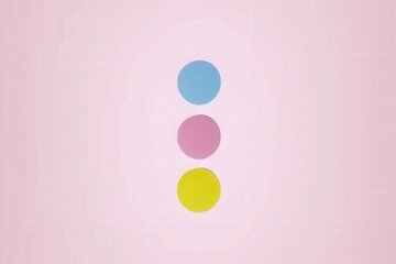 Three colorful circles (blue, pink, yellow) arranged vertically on a soft pink background create a minimalistic and playful design.