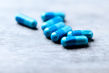 Amino acids capsules on wooden background. Soft focus. Close up.