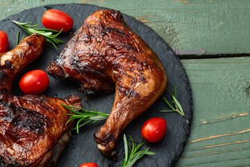 Grilled chicken legs with tomatoes and salad . Top view