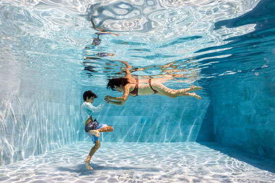 Mother and Son playing underwater in a pool 