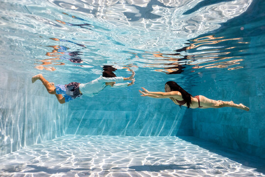 Mother and Son playing underwater in a pool 