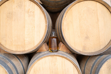 Botella de tequila entre barricas de madera en la fábrica.