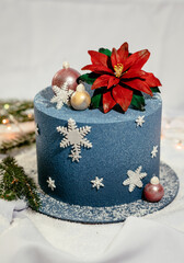 Delicious blue cake decorated in New Year's style. Festive Christmas cake decorated with spheres and snowflakes. New Year's dessert