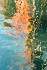 Naklejka premium Stunning orchids with vibrant colors reflected in water against a dark background, creating a mesmerizing visual effect.