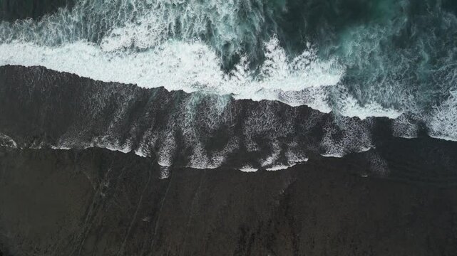 4k video footage - Aerial view of Watu Karung Beach, Pacitan, East Java, Indonesia with crashing waves during cloudy day. Cape with cliffs by the sea and green plants around at tropical island