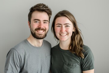 Obraz premium Portrait of a smiling couple in their 20s dressed in a casual t-shirt on pastel gray background