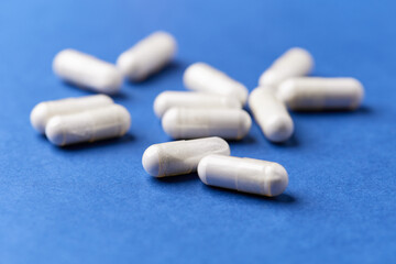 Tyrosine capsules (one of the 20 standard amino acids). A dietary supplement used to improve attention and focus on paper background. Soft focus. Close up.	