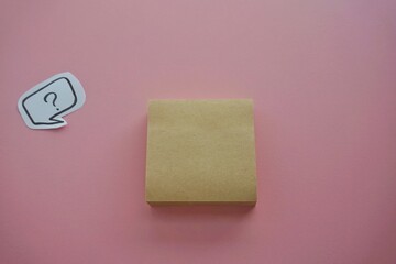 question mark in speech bubble on pink background. A piece of paper with a question mark, pinned to a pink surface, evoking curiosity. blank sticky notes.
