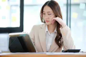 Businesswoman feeling stressed while analyzing data at her desk