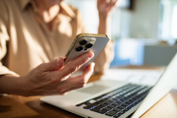 Fototapeta premium Woman working on laptop at kitchen desk at home