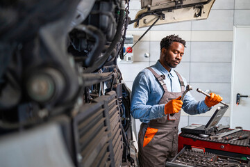 Hardworking truck serviceman preparing tools to fix the vehicle engine.