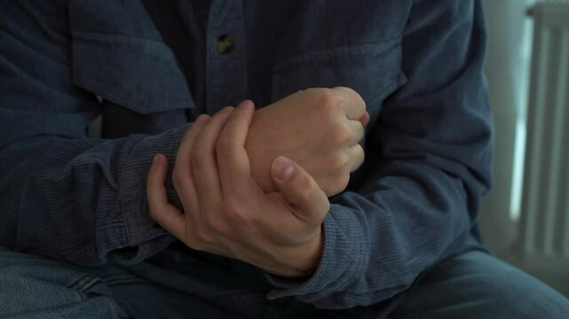 A young guy in a blue shirt massages his injured arm.
A man rotates his hand.
A young guy has pain in his arm.
Hand bruise