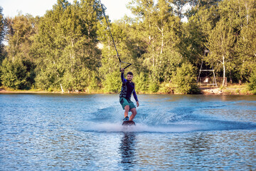 A man wakeboarding on a lake on summer day in a life  jacket. Soft focus. Action blur: Abakan,...