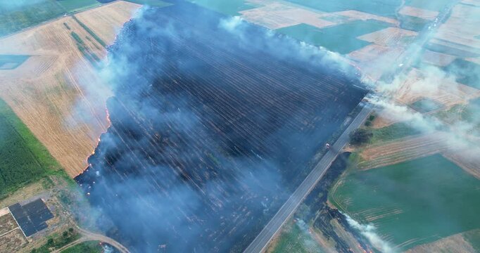 Sky with smoke from burning agriculture bush fields in the background, aerial view