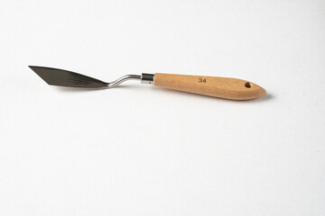 Palette knife on a white canvas. A clean new palette knife on canvas. A drawing tool.