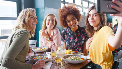 Group Of Young Female Friends Posing For Selfie In Restaurant Before Eating Meal