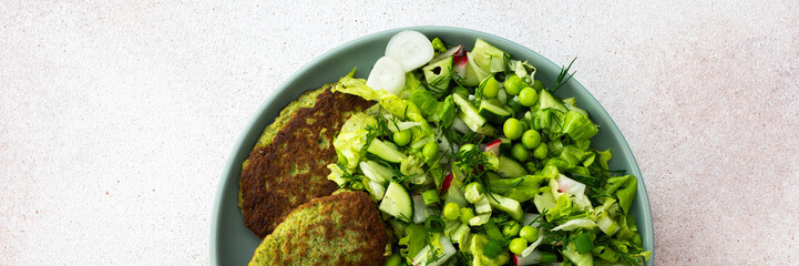 Enjoy zucchini and broccoli pancakes paired with a fresh mixed salad featuring cucumbers, young...