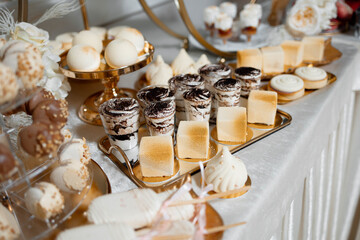 A table full of desserts including cakes, cookies, and other sweet treats. The table is set up for a party or gathering