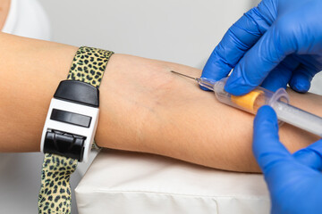 Nurse taking a blood sample from a patients arm