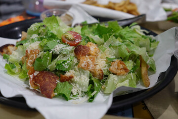 Caesar Salad. A plate of classic Caesar salad, featuring romaine lettuce, croutons, Parmesan cheese, and Caesar dressing, perfect for salad menus