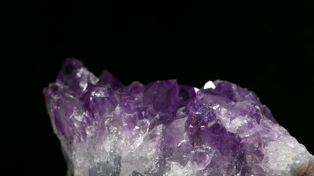 Amethyst (purple quartz) crystals sample rotating against a black background	