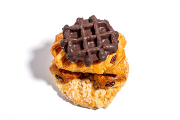 A waffle covered in chocolate sits on top of a pastry. The combination of the sweet waffle and the rich chocolate creates a delicious and indulgent treat Sweet pastries isolated on white background.
