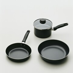 A set of black cooking pots and pans arranged on a plain background.