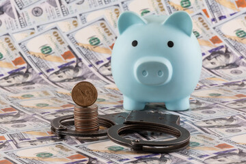 Handcuffs and American coins against the background of US $100 bills