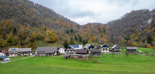 Idyllic mountain village with houses using solar panels in autumn, slovenia