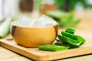 aloe vera and pieces of its pulp on a wooden pit