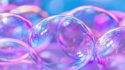 Colorful soap bubbles shining in bright light against a blue background