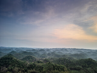 Aerial view of Gunung Sewu Geopark or Sewu Mountains, Pacitan, East Java, Indonesia. Unique karstic landscape with many conical hills in the morning with mist.