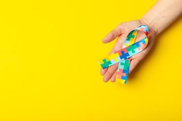 Autism ribbon. Autism awareness day. World autism awareness day with puzzle pattern ribbon on textured background. Colorful puzzle ribbon. Medicine concept. Space for text. Copy space