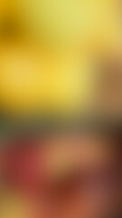 Colorful blurry gradient background featuring smooth transitions between orange, red, yellow, green, and dark hues for abstract designs. Vertical background in warm autumn colors.