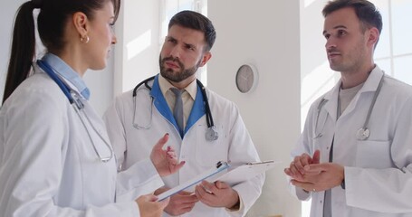 Team of professional doctors and nurses discussing medical topics during a conference in a hospital office. Professionals group teamwork reflects commitment to healthcare and collaboration.