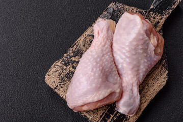 Raw chicken legs with salt, spices, herbs and tomatoes