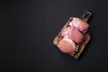 Fresh raw chicken thigh fillets with salt, spices and herbs