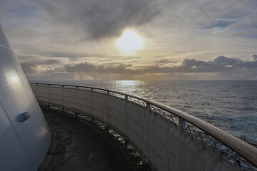 Breathtaking sunset sunrise ocean view from outdoor teak pool promenade deck of ocean liner at sea...
