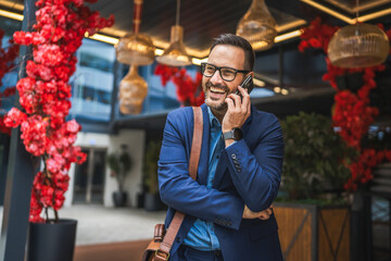 adult businessman stand in front restaurant and talk on mobile phone