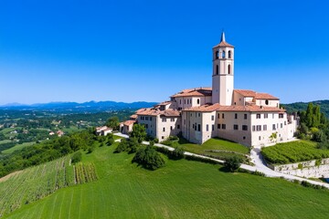 Naklejka premium A drone-shot image of a medieval castle on a hilltop, surrounded by rolling green fields