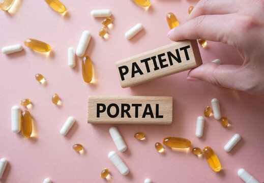 Patient Portal symbol. Concept word Patient Portal on wooden blocks. Beautiful pink background with pills. Doctor Hand. Medicine and Patient Portal concept. Copy space