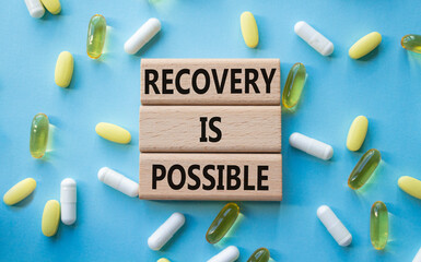Recovery is possible symbol. Concept words Recovery is possible on wooden blocks. Beautiful blue...
