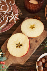 Two halves of a red apple with a star in the middle with gingerbread Christmas cookies