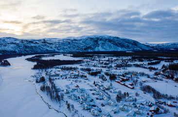 Alta, Norway. Aerial view of small northern town Alta, Norway in winter. Aerial with houses, river and mountain in the evening