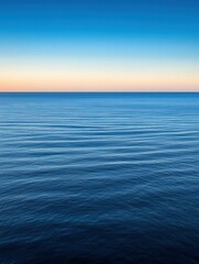 Obraz premium Tranquil sunset over calm ocean waters during twilight hours