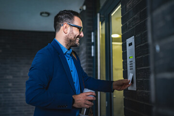 businessman use access card at building entrance with a smile