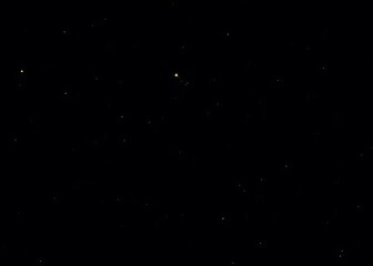 A starry sky with a black background features numerous small yellow dots, a prominent star cluster, and a distant glimpse of the Milky Way.