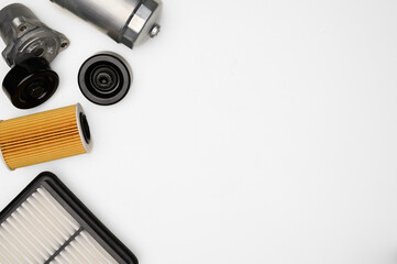 Top view of layout of auto parts, filters on white background, tensioner roller. Car oil filter,...