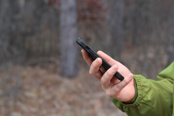 macro close-up of person using mobile smartphone phone device outdoors background